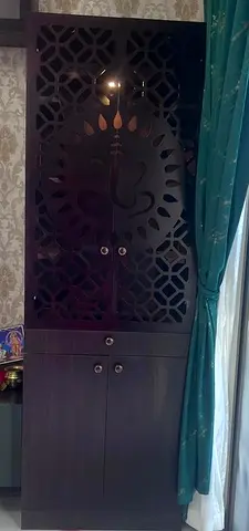 Tall dark wood cabinet with decorative cutout doors — good condition