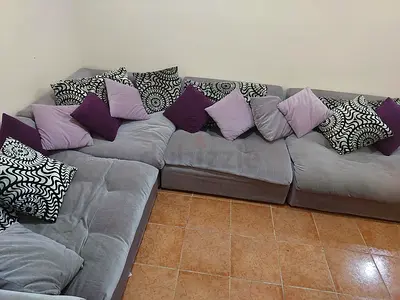 Large L-shaped grey fabric sofa with cushions - good condition