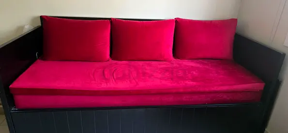 Solid black extendable daybed with red velvet cushions - good condition