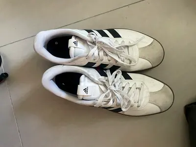 White Adidas casual sneakers with black stripes, lightly used