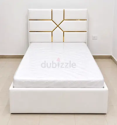 Single white upholstered bed with geometric headboard and mattress