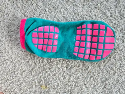 Pair of non-slip socks (green with pink grips) — only once used