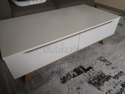 White modern coffee table with drawers and wooden legs