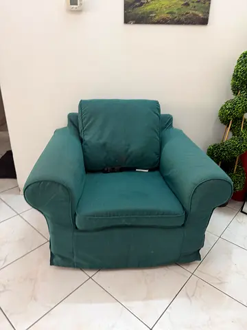 Comfortable teal-green upholstered armchair in good condition