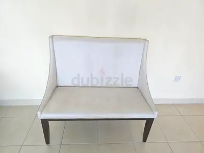 Two-seater upholstered bench / loveseat in cream fabric with wooden legs
