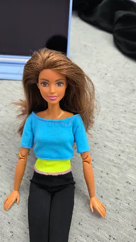 Barbie Made to Move doll with brunette hair wearing a blue and yellow top and black leggings.