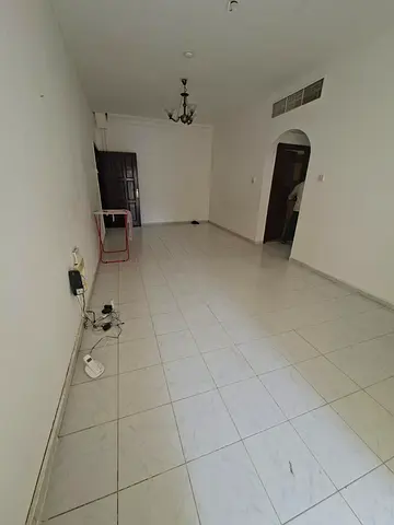 Annual rental in Al Qulaya, Sharjah. One-bedroom apartment with living room, balcony, bathroom and central AC. Rent AED 30,000 yearly. Payment in 4 or