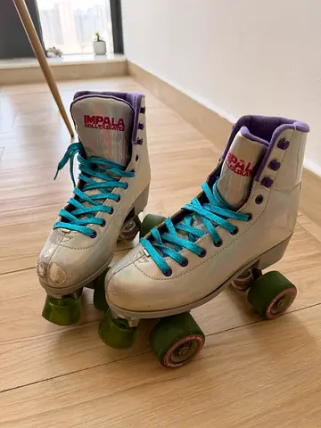 Used silver quad roller skates with teal laces (womens) - good condition