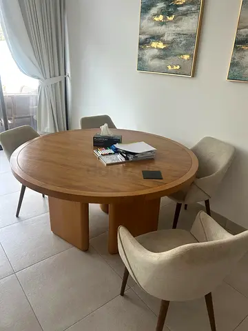 Round wooden dining table with six upholstered chairs