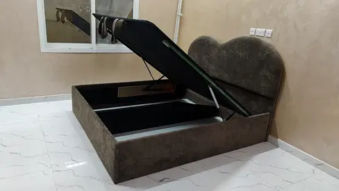 Queen storage bed with gas-lift compartment and upholstered heart-shaped headboard
