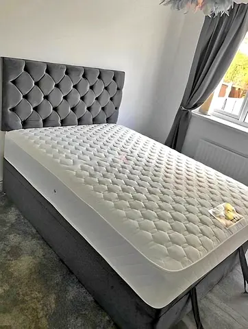 Grey upholstered double bed frame with mattress