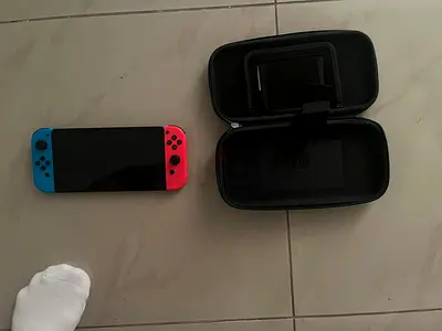 Nintendo Switch console with neon Joy-Con and travel case