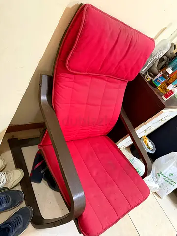 IKEA-style red cushioned lounge chair with wooden frame