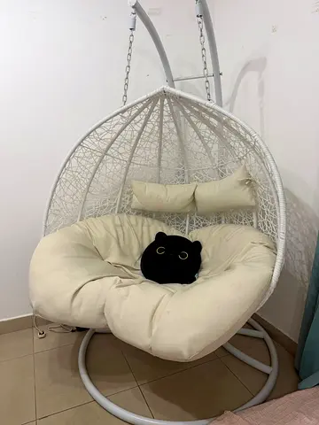 White hanging egg rattan chair with cushion and stand
