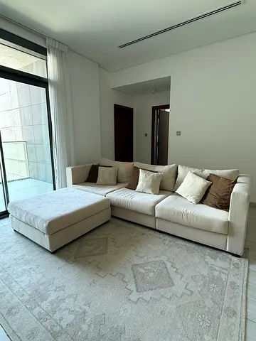Light beige L-shaped sofa with ottoman — good condition