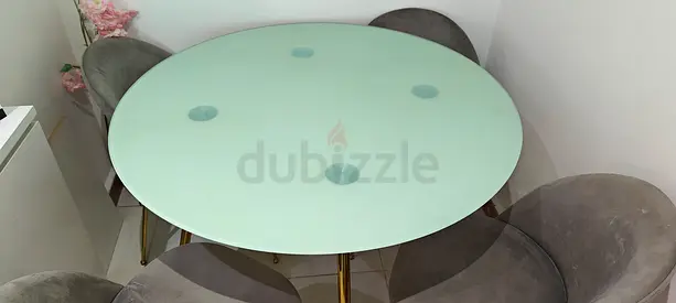 Round glass dining table with gold legs and 4 upholstered chairs