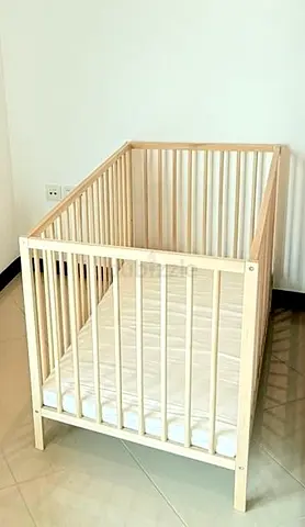 Light wood baby crib with mattress - solid slatted design
