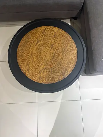 Round wooden-top side table with black frame — good condition