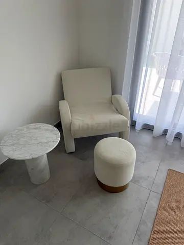 Cream boucle lounge chair with matching ottoman