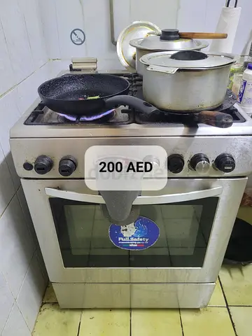 Used stainless steel gas stove with oven - functional, 4 burners, 200 AED
