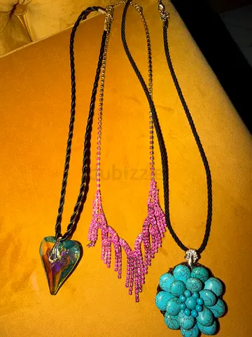 Three fashion necklaces — turquoise flower, pink beaded fringe, and iridescent heart