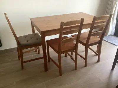 Solid wood dining table with four matching chairs - simple, good condition.