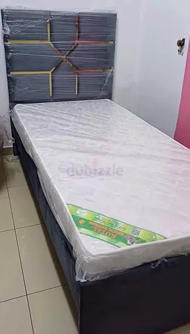 Single bed with mattress and upholstered headboard