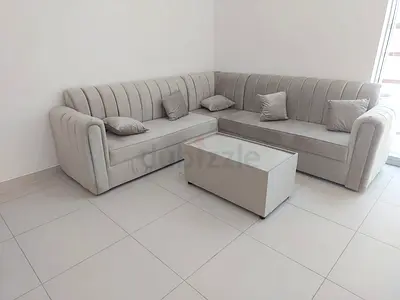 Light grey L-shaped velvet corner sofa with center storage coffee table