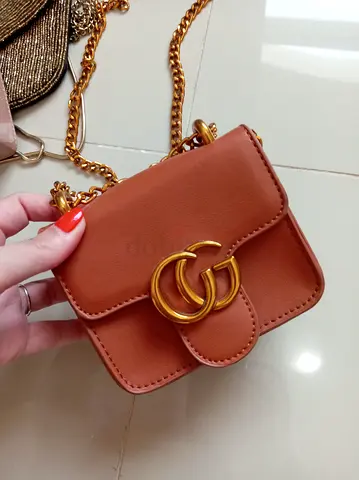Small brown leather crossbody bag with gold chain and double-G logo