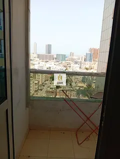 A studio apartment with a balcony, furniture, and parking is available for annual rent in Ajman. The