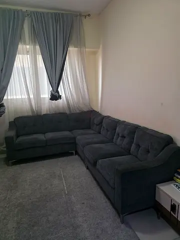 Dark grey L-shaped fabric corner sofa — good condition