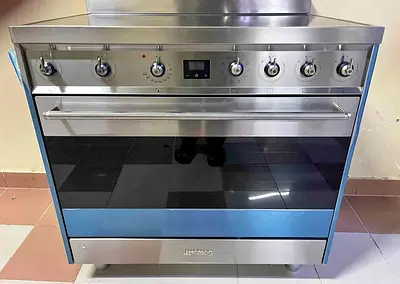 Smeg induction cooker, featuring stainless steel construction and a black glass cooktop.