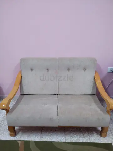 Two-seater wooden-framed sofa in beige, good condition