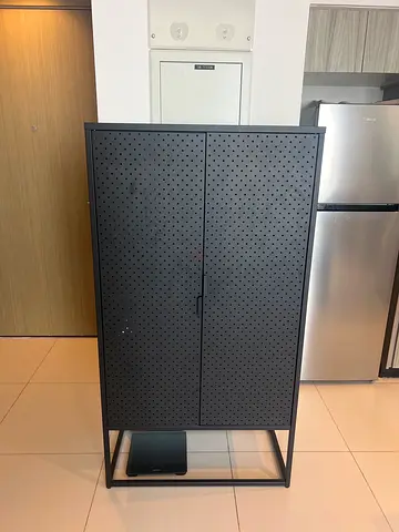 Black metal storage cabinet with pegboard doors — modern industrial