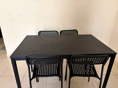 Ikea Black dining table with four matching perforated chairs - sturdy set