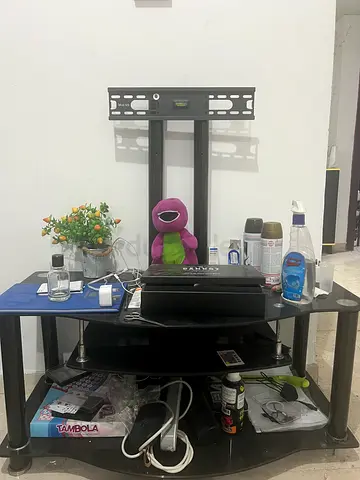 Selling a black glass TV stand in good condition. Comes with a wall mounting bracket for the TV.