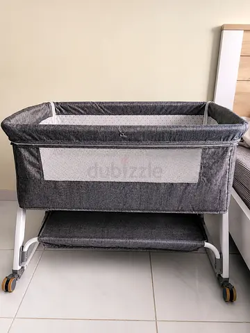 Grey bedside bassinet with storage shelf, wheeled and adjustable height and safety net (detachable)