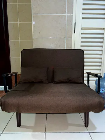 Compact brown upholstered two-seater sofa cum single bed in good condition