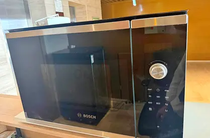 Bosch built-in microwave features a sleek black glass finish and stainless steel
