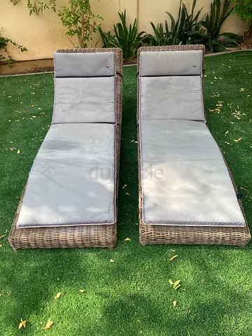 Pair of rattan outdoor sun loungers with cushions