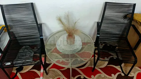 Pair of black rope-style patio chairs with small round metal side table