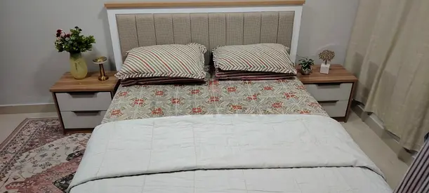 Bed with upholstered headboard and matching bedside tables