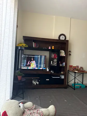 Dark wood TV entertainment center with shelves and cabinets