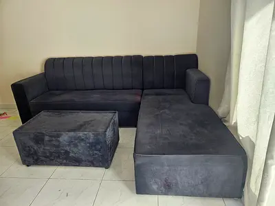 Dark grey L-shaped velvet sofa with ottoman - good condition with cover
