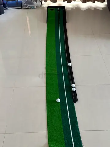 Indoor golf putting mat with ball return