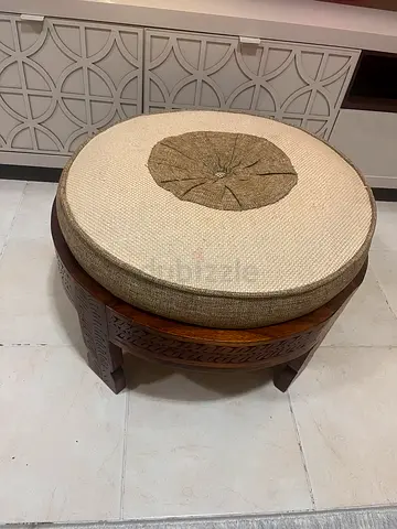 Small carved wooden stool with beige cushion (38 cm height)