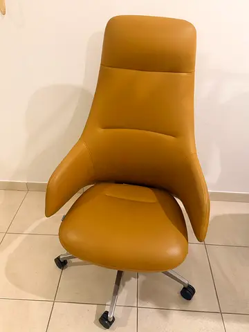 Comfortable tan leather high-back office chair on wheels