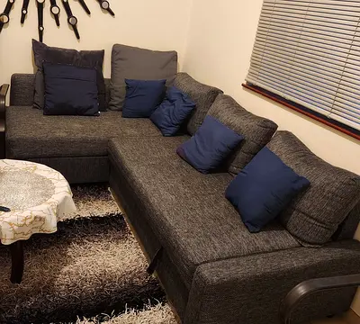 Grey L-shaped Corner Sofa with Cushions - Good Condition