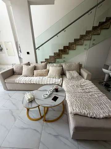 Light beige L-shaped corner sofa in average condition