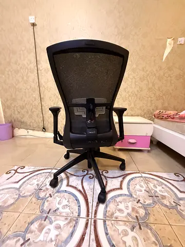 Ergonomic black mesh office chair with adjustable armrests and wheels